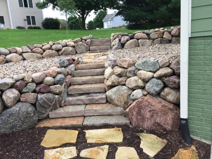 Boulder retaining wall with natural stone steps
